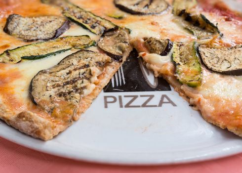In the picture a whole wheat pizza with eggplant , zucchini , tomato and Neapolitan buffalo mozzarella.( Bufala campana)