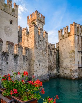 A Scaliger Castle (13th Century) with foreground red geraniums.