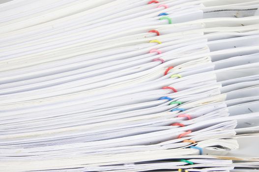 Stack paperwork with colorful paper clip overlap old report of sales and receipt.