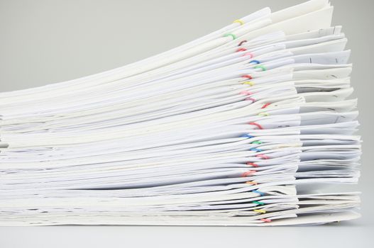 Stack paperwork with colorful paper clip overlap report of sales and receipt on white background.