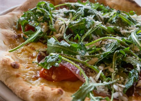 Italian pizza Valtellinese with parmesan cheese,tomato, tomato cherry,mozzarella,arugula.