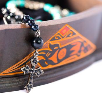 A rosary coming out of a carved box in wood