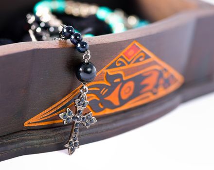 A rosary coming out of a carved box in wood