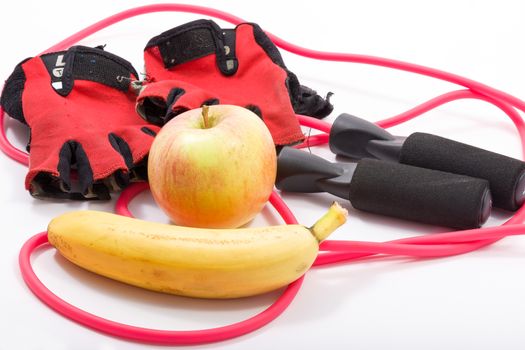 In this photo skinning rope,gloves gym,banana and apple.