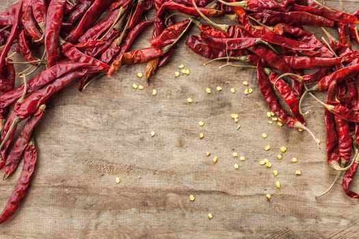 Dried red chili pepper isolated on wooden background .