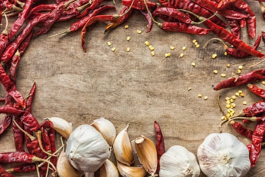 Dried red chili pepper and fresh garlic isolated on wooden background .