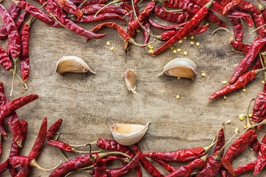 Dried red chili pepper and fresh garlic isolated on wooden background .