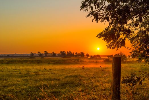 Countryside landscape in a misty morning with a sunrise