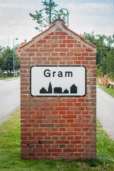 Gram city sign on a red brick post