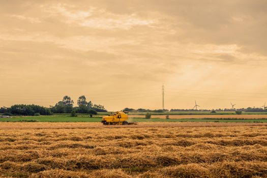 Agricultural machine on a field with hay