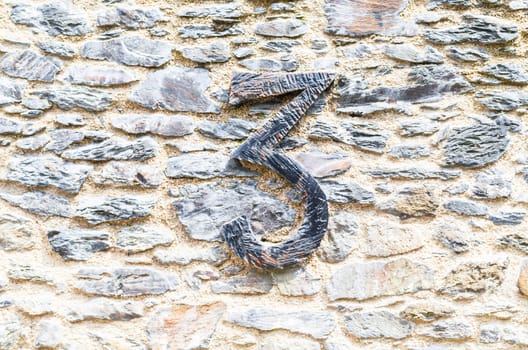 Old castle stone wall with speed Nr. 3 in wrought iron. texture background