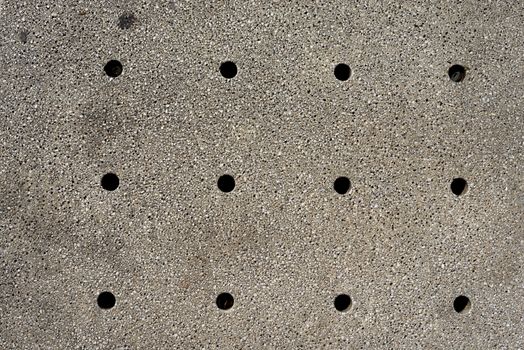 Holes in gray wall, texture background. Close up view