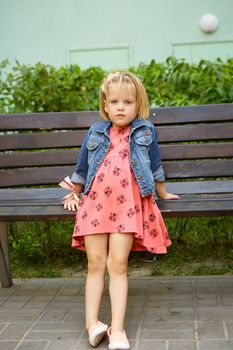 Portrait of funny little child, adorable blonde toddler girl outdoors