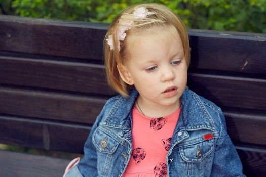 Portrait of funny little child, adorable blonde toddler girl outdoors