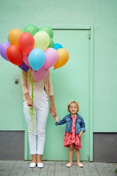 mother and child with colorful balloons mother and child with colorful balloons on green background