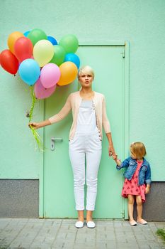 mother and child with colorful balloons mother and child with colorful balloons on green background