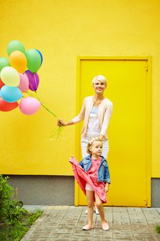mother and child with colorful balloons on a yellow background
