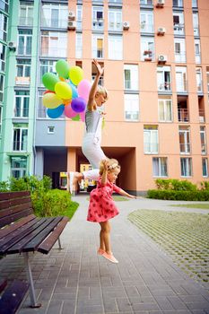 summer holidays, celebration, family, children and people concept - mother and child with colorful balloons, jumping