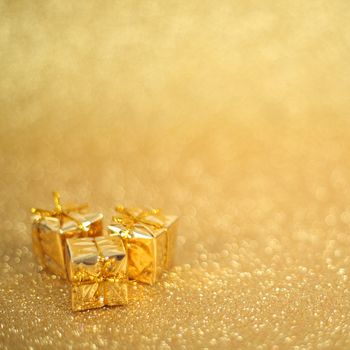 Holiday gift boxes on shiny golden background with copy space