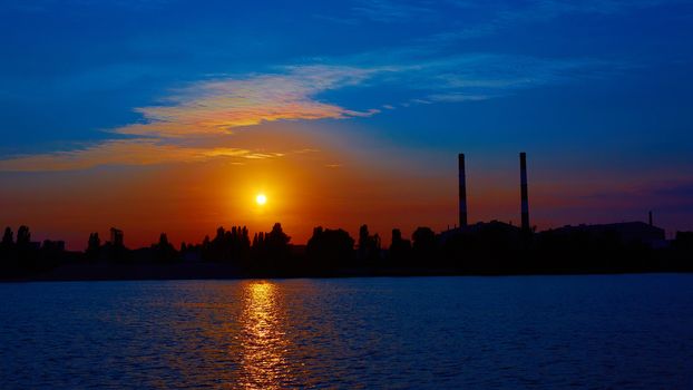 Oil refinery factory in silhouette and sunrise sky