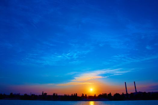 Oil refinery factory in silhouette and sunrise sky