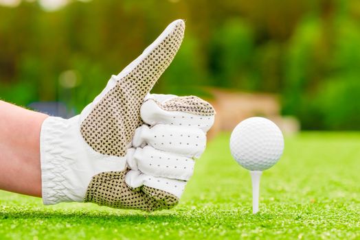 Positive hand gesture near the golf ball on a tee