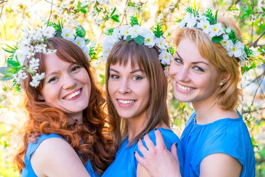 romantic portrait of three women at the time of flowering cherry in the park