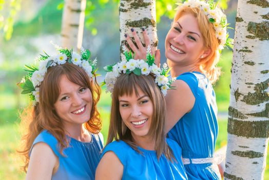 happy girlfriends posing near birch in the spring park