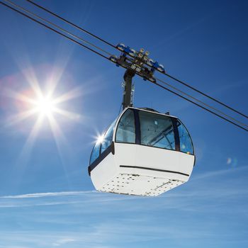 Cable car and sun in a mountain area