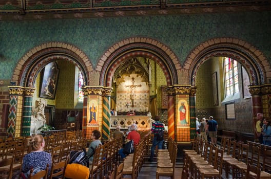 Bruges, Belgium - May 11, 2015: Tourists visit Interior of Basilica of the Holy Blood in Bruges, Belgium on May 11, 2015. Basilica is located in the Burg square and consists of a lower and upper chapel. 