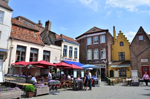 Bruges, Belgium - May 11, 2015: Tourist at outdoor cafe in Bruges, Belgium. Bruges is the capital and largest city of the province of West Flanders in the Flemish Region of Belgium. 