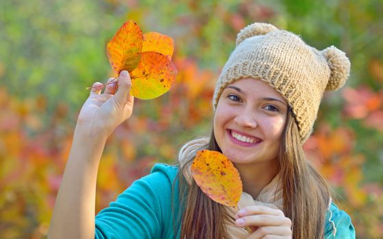 Happy girl with dry leaves  in forest