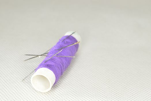 purple yarn with needles for sewing