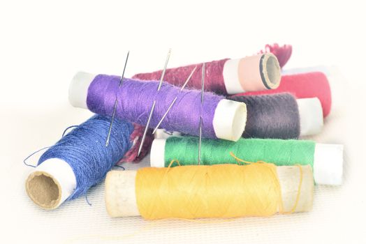 set of colored threads with needles and blade for sewing