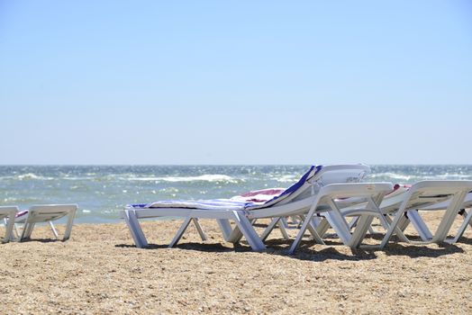 white sunbed near sea on sand ( summer holiday)