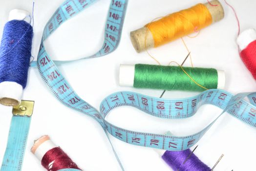 sewing fashion background ( retro blue  ruler and many colored clew  with needles for sewing )