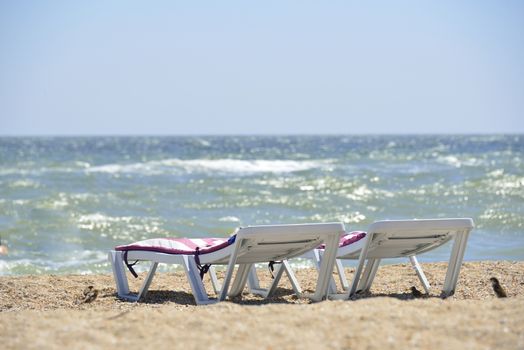 white sunbed near sea on sand ( summer holiday)