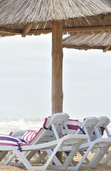 white sunbed near sea on sand ( summer holiday)