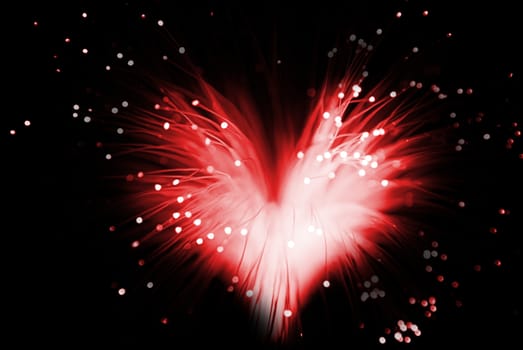 red colored abstract heart made from fibers  lights  in darkness ( love concept )