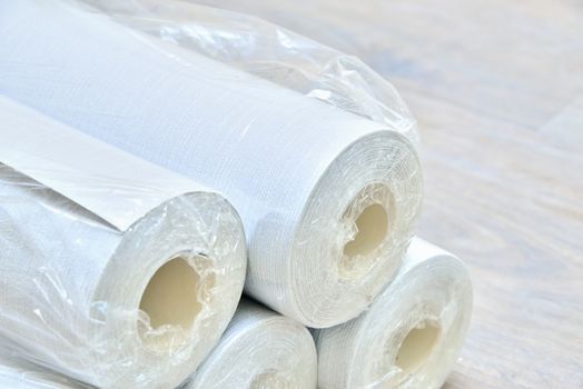 Many gray wallpaper rolls on floor