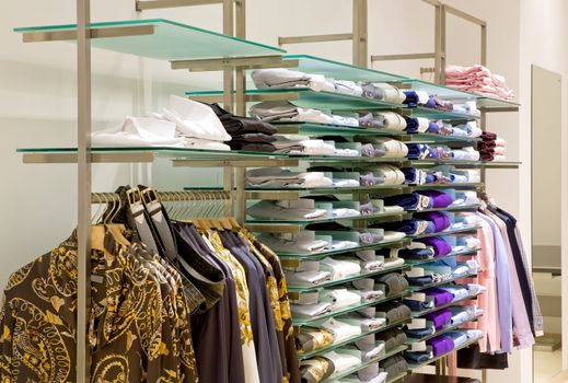 inside fashion store (Men's and women's shirts, blouses and accessories on hangers )