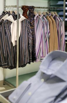 inside fashion store (Men's and women's shirts, blouses and accessories on hangers )