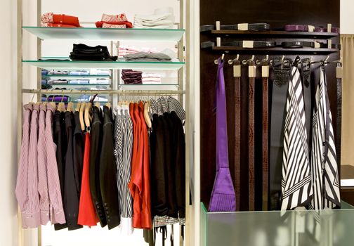 inside fashion store (Men's and women's shirts, blouses and accessories on hangers )