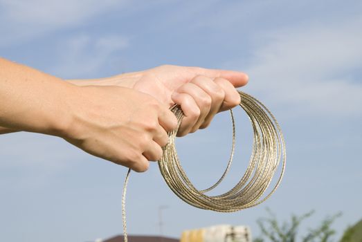 shiny rope in hands on sky backgroung