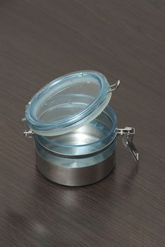 empty  metallic food container with blue glass cap