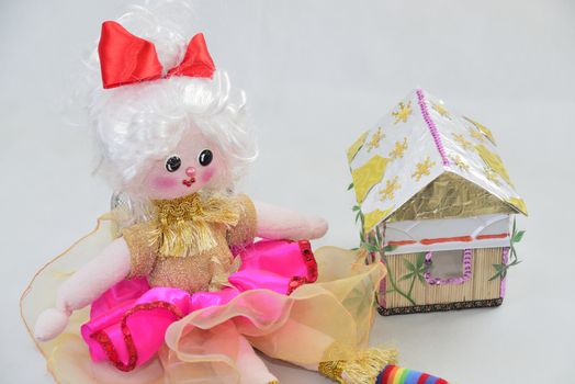 girl's doll with small house over white