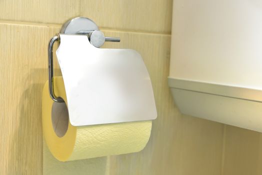 Toilet yellow paper and toilet paper holder.