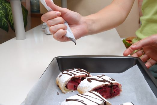 Swiss rolls  decorated by chocolate (hand squeezes cream)