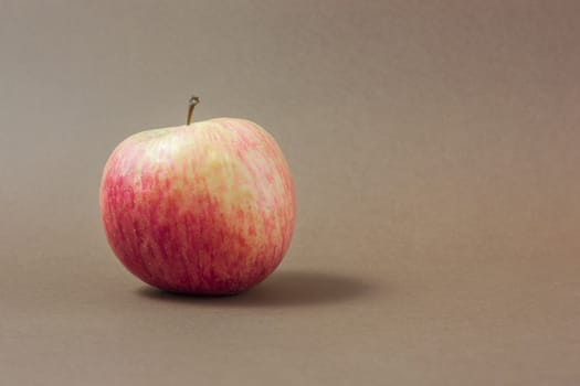 Ripe red apple on a brown background