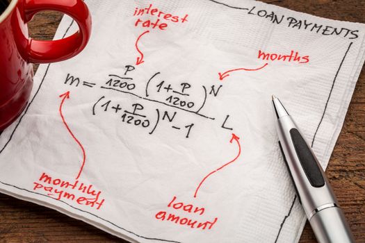 loan payment equation sketched on a white napkin with a cup of coffee